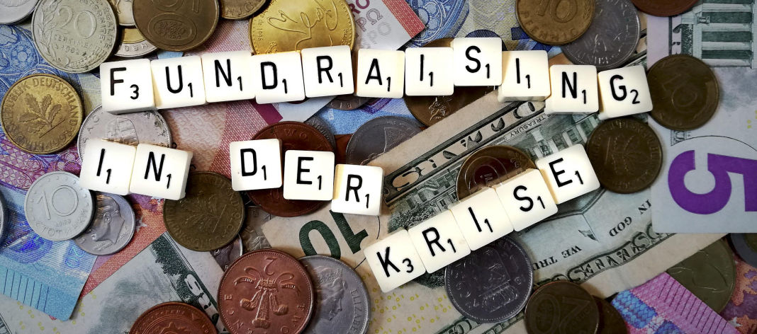 Fundraising in der Krise - dargestellt mit Scrabble-Steinen auf Geldscheinen und Münzen